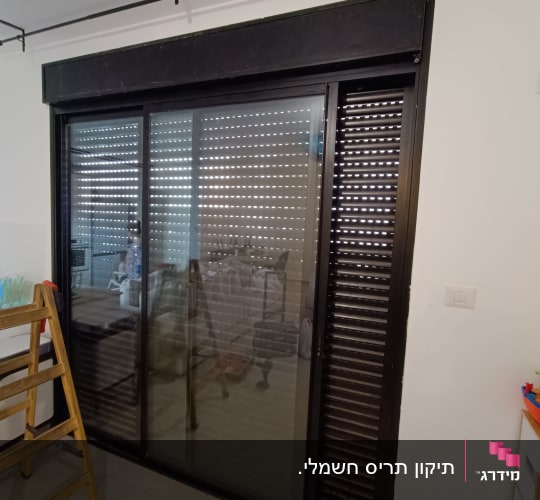 תריסים שחורים על חלון זכוכית גדול